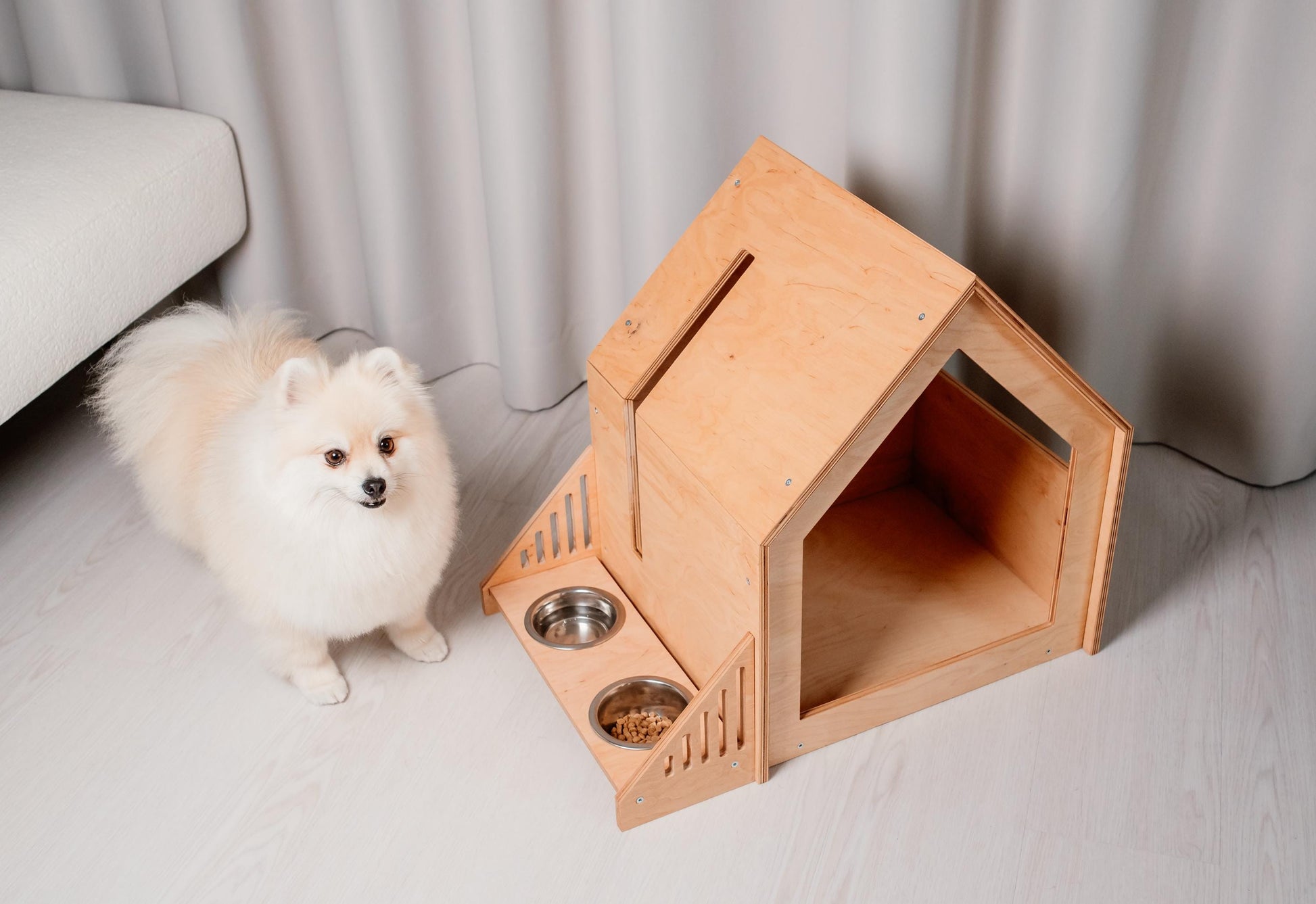 Small wooden dog house with feeder in natural wood finish, cozy indoor puppy shelter