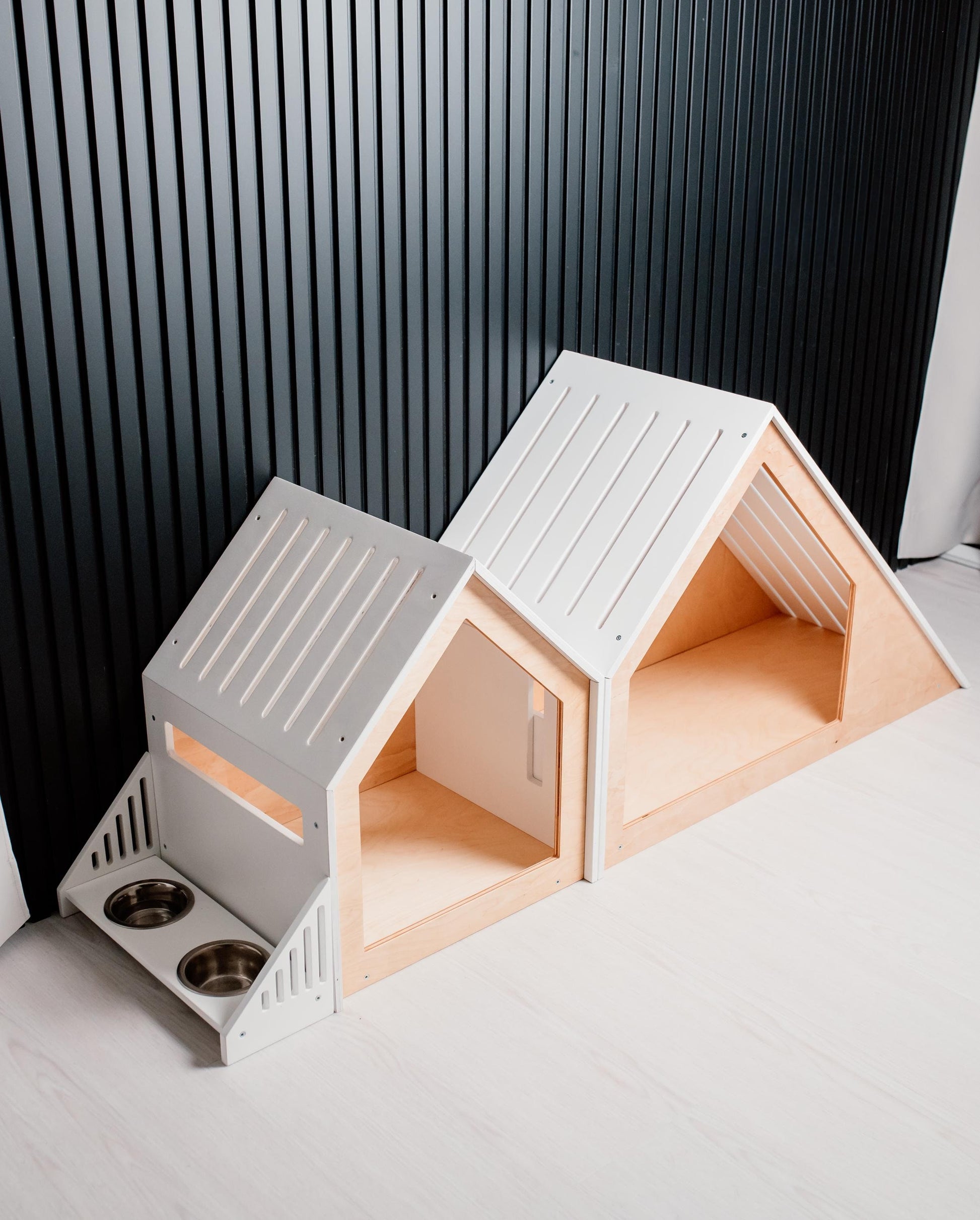 Front view of matching white wooden indoor dog houses